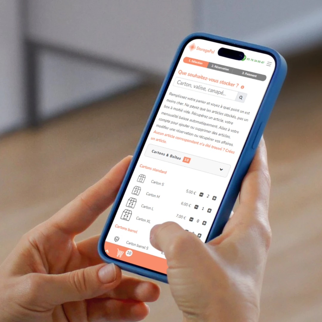 Hands holding a phone showing the StoragePal app booking flow