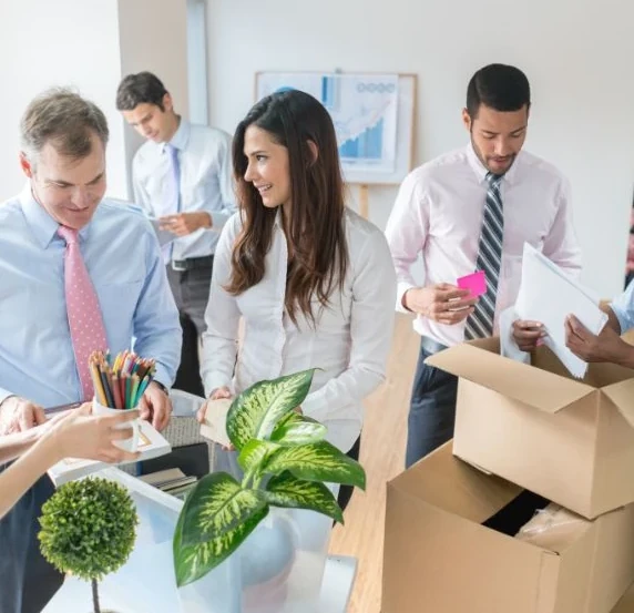Coworkers filling storage boxes to declutter their office in Paris